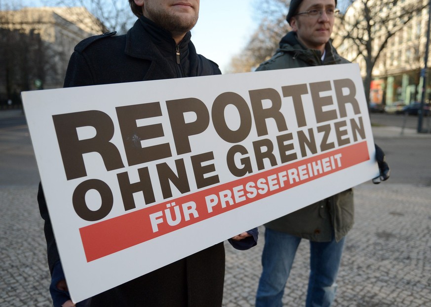 epa04054303 Protesters of the organization &#039;Reporter ohne Grenzen&#039; (lit. Reporters Without Borders, or RWB) hold a placard &#039;for freedom of press&#039; as they stand in front of the Russ ...