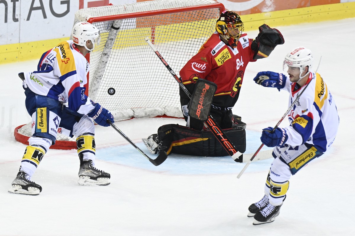 Berns Goalie Daniel Manzato, Mitte, geschlagen von Klotens Marc Marchon, rechts, und Eric Faille, links, im Eishockey-Meisterschaftsspiel der National League zwischen dem SC Bern und dem EHC Kloten am ...
