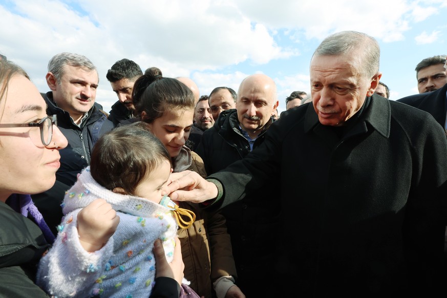 epa10459137 A handout photo made available by Turkey&#039;s Presidential press office shows Turkish President Recep Tayyip Erdogan (R) greeting people as he visits a tent camp in the aftermath of a ma ...