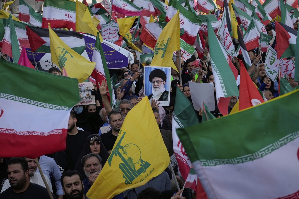 Demonstrators wave Iranian and Hezbollah flags as one holds up a poster of Iran's Supreme Leader Ayatollah Ali Khamenei during a rally marking the Muslim Shiite holiday of Eid al-Ghadir, which co ...
