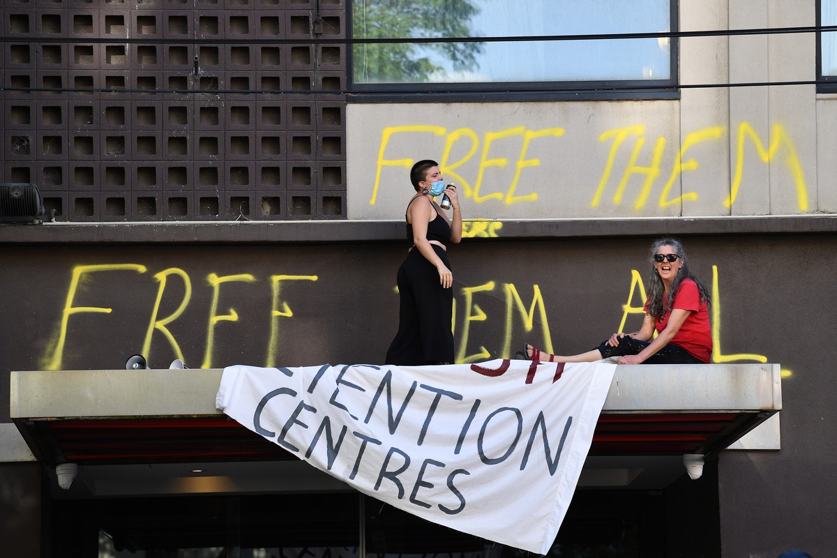 epa09669092 Protesters are seen outside of the Park hotel quarantine facility where it is believed Serbian tennis player Novak Djokovic is being detained in Melbourne, Australia, 06 January 2022. Worl ...