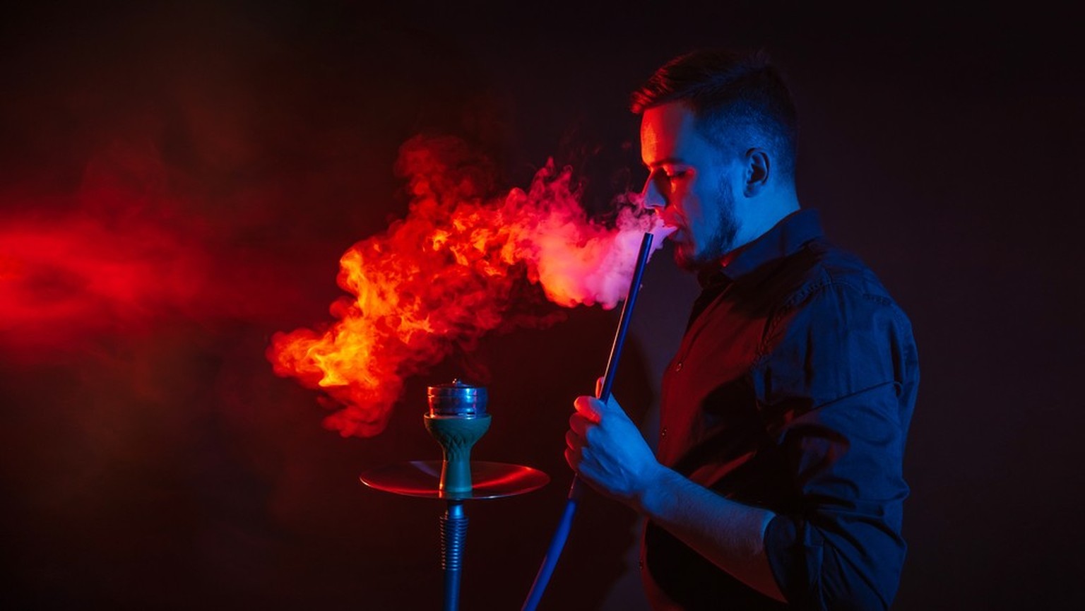 Ein Mann raucht Shisha.