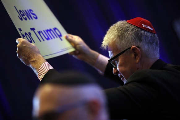 epa07488908 A guest holds a poster reading &#039;We Are Jews for Trump&#039; as he attends a Republican Jewish Coalition meeting in Las Vegas, Nevada, USA, 06 April 2019. US President Donald J. Trump  ...