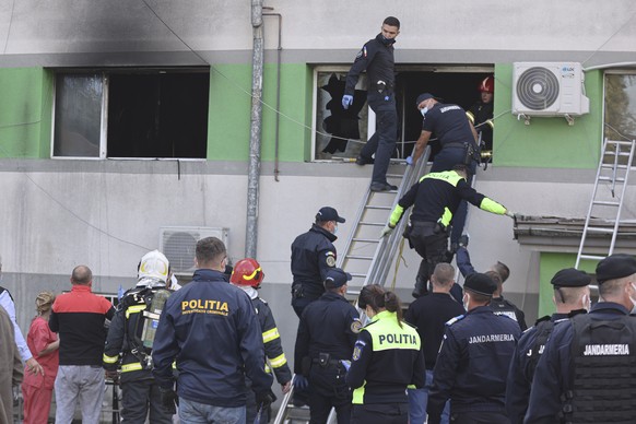 Emergency personnel exit through a window after a fire in the COVID-19 ICU section of the Hospital for Infectious Diseases in the Black Sea port of Constanta, Romania, Friday, Oct. 1, 2021. Authoritie ...