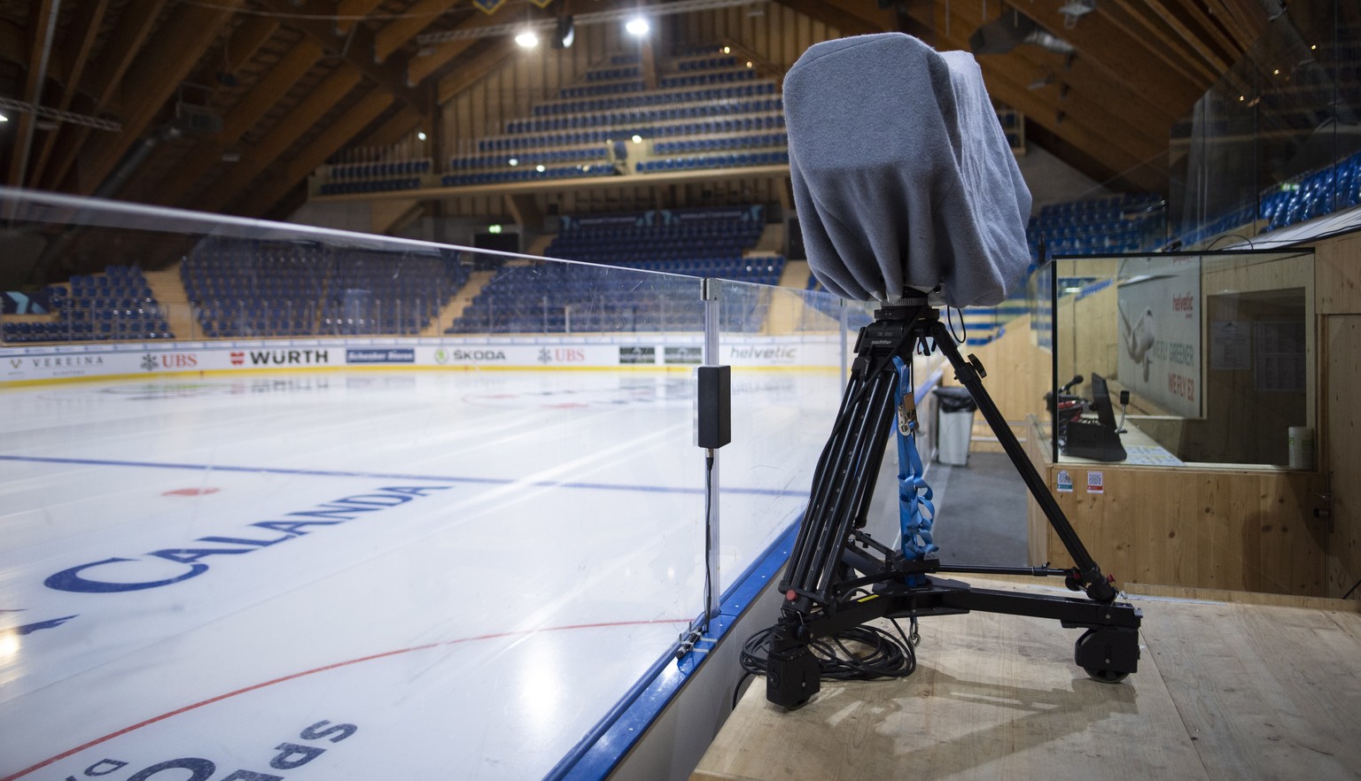 epa09656468 A covered TV camera stands among empty stands at the ice stadium in Davos, Switzerland, 25 December 2021. The 94th Spengler Cup was canceled one day before the start of the traditional tou ...