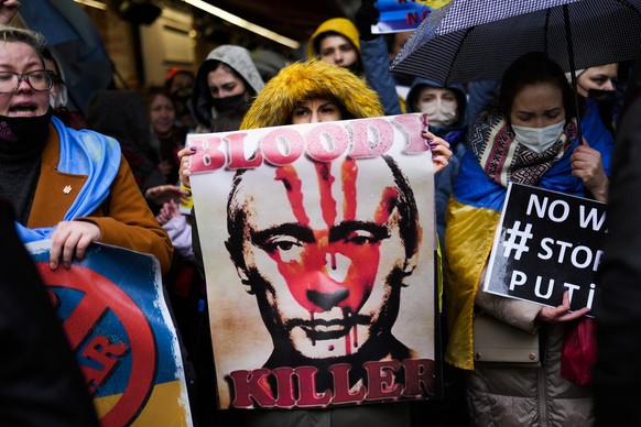 People hold banners and shout slogans during a small protest outside the Russian consulate in Istanbul, Turkey, Thursday, Feb. 24, 2022, after Russian troops launched an attack on Ukraine. (AP Photo/F ...