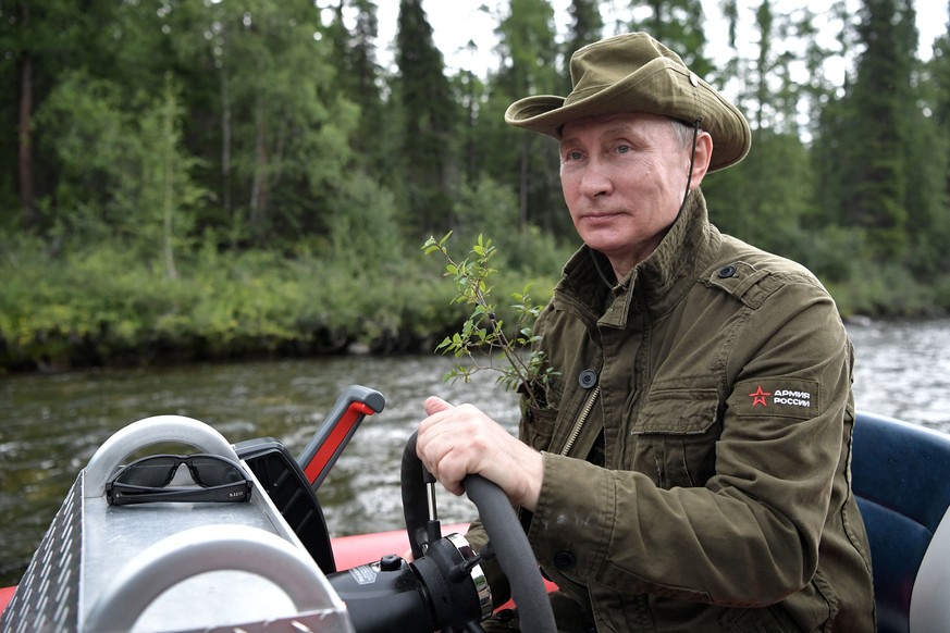 epa06125616 Russian President Vladimir Putin driving a motor boat at the cascade of mountain lakes during his vacation on 01-03 August 2017, (issued 05 August 2017) in the Tyva Republic in the souther ...