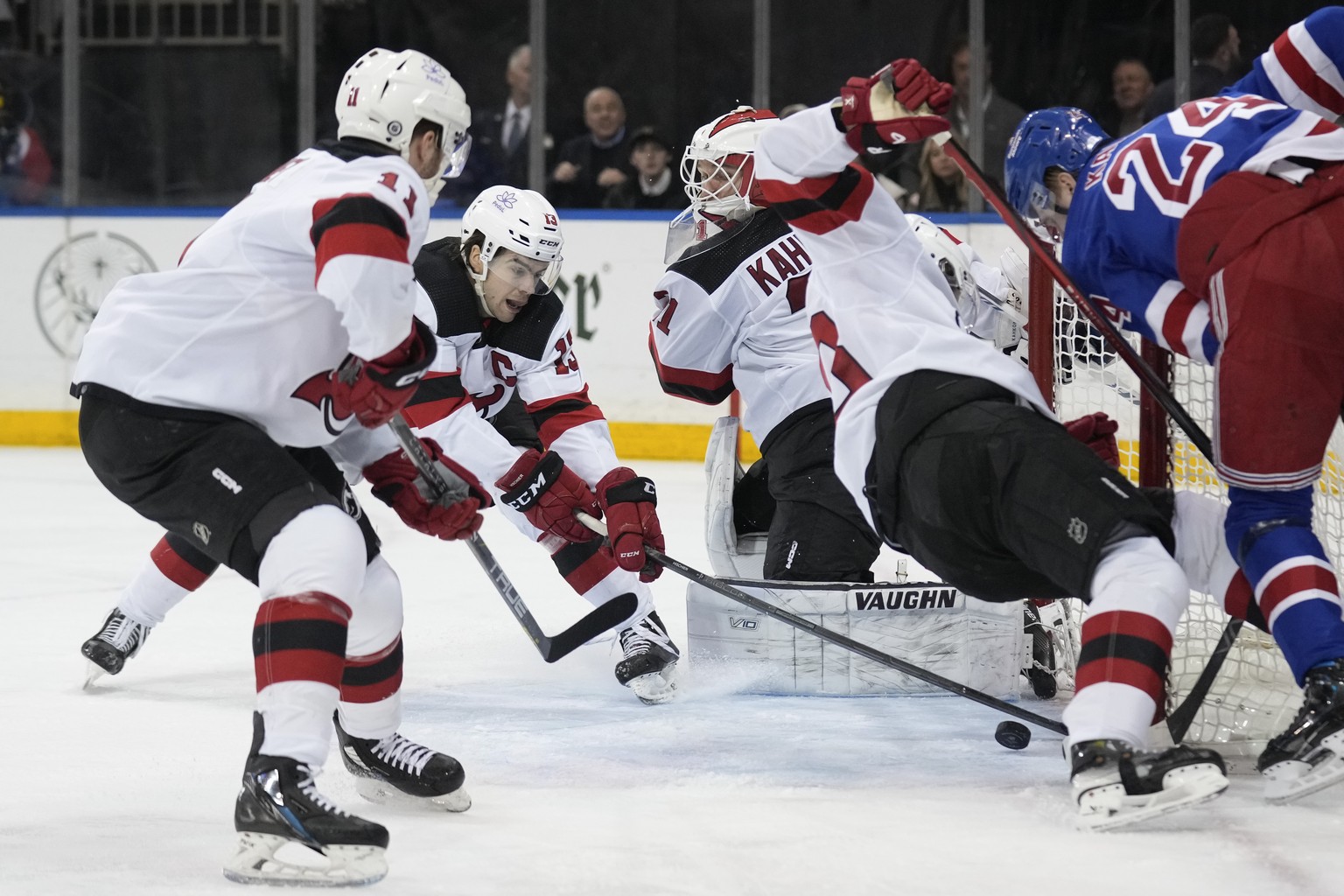 New Jersey Devils&#039; Nico Hischier, second from left, gets the puck away from the net and goaltender Kaapo Kahkonen, third from left, during the second period of an NHL hockey game against the New  ...