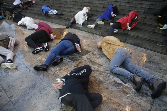 epaselect epa09874096 People with tied arms laying on the ground reenact how Ukrainian civilians killed in Bucha, Ukraine were found, take part in a performance to support Ukraine in front of the Parl ...