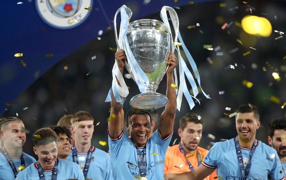 epa10684507 Manchester City player Manuel Akanji.  He raises the trophy as the team celebrates victory in the Champions League final between Manchester City and Inter Milan, in Istanbul, Tu...