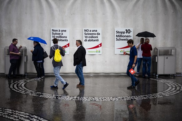 Sympathisanten vor Plakaten mit der Aufschrift &quot;Stopp 10-Millionen-Schweiz&quot; vor der Swiss Life Arena beim Wahlauftakt Anlass der SVP Schweiz in der Swiss Life Arena, am Samstag, 26. August 2 ...
