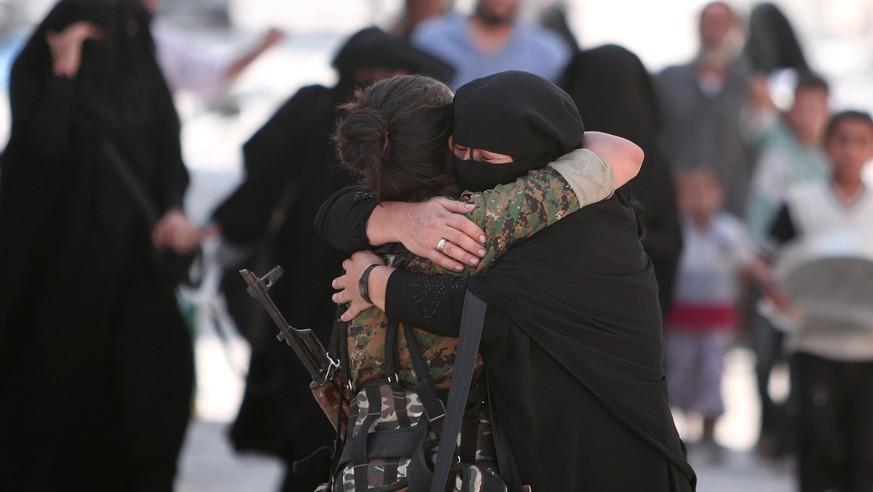 A woman embraces a Syria Democratic Forces (SDF) fighter after she was evacuated with others by the SDF from an Islamic State-controlled neighbourhood of Manbij, in Aleppo Governorate, Syria, August 1 ...