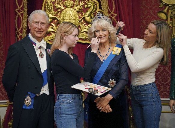 Studio artists Sophie Greenaway, second left and Claire Parkes add the finishing touches to a new Camilla, Queen Consort wax figure at Madame Tussauds in London, Wednesday April 26, 2023 ahead of the  ...