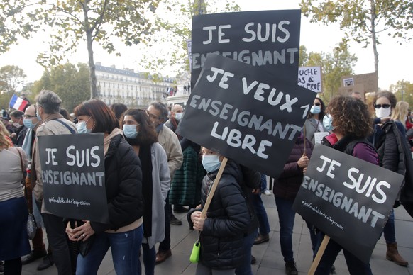 Demonstrators hold placards reading &quot;I am a teacher&quot; during a demonstration Sunday Oct. 18, 2020 in Paris. Demonstrations around France have been called in support of freedom of speech and t ...