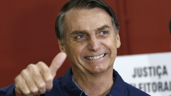 FILE - In this Oct. 7, 2018 file photo, presidential frontrunner Jair Bolsonaro, of the Social Liberal Party, flashes a thumbs up at a polling station in Rio de Janeiro, Brazil. In the first round of  ...