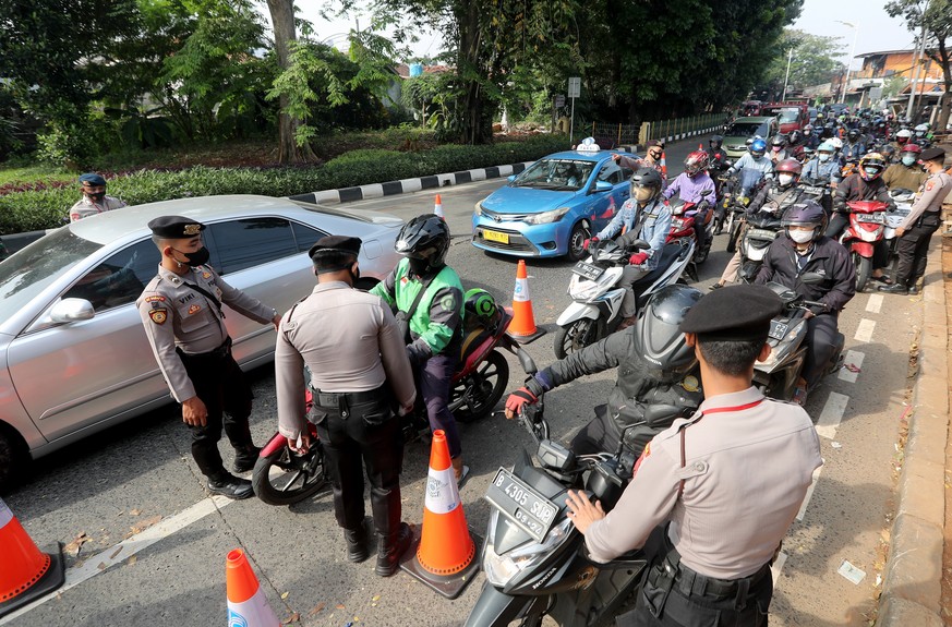 epa09330689 Indonesian police officers inspect motorists at a check point, enforcing the imposition of COVID-19 emergency restrictions in Jakarta, Indonesia, 08 July 2021. Indonesian authorities will  ...