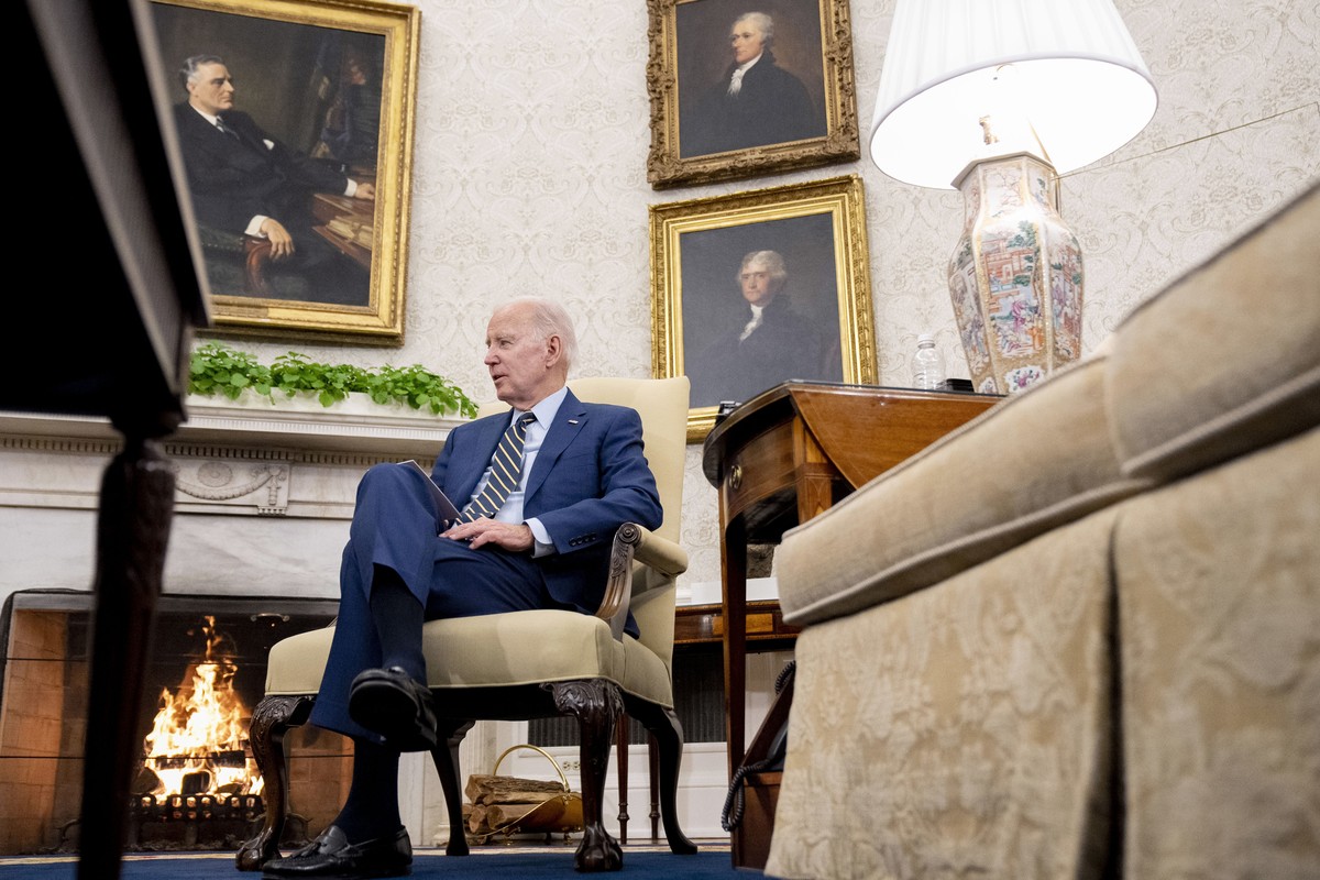 Joe Biden dans le Bureau ovale, avec des peintures de trois anciens présidents américains en toile de fond.