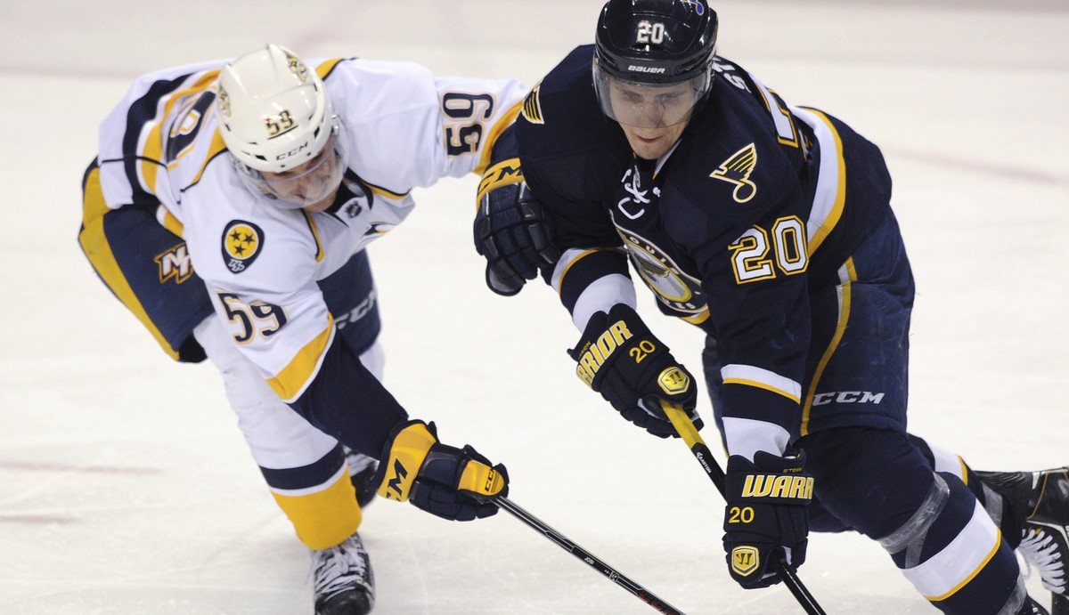 St. Louis Blues' Alexander Steen (20) and Nashville Predators' Roman Josi (59), of Switzerland, reach for the puck during the third period of an NHL hockey game Saturday, Feb. 1, 2014, in St ...