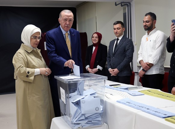 epa11252627 A handout photo made available by the Turkish President Press Office shows Turkish President Recep Tayyip Erdogan (C) and his wife Emine Erdogan (L) voting at a polling station during the  ...