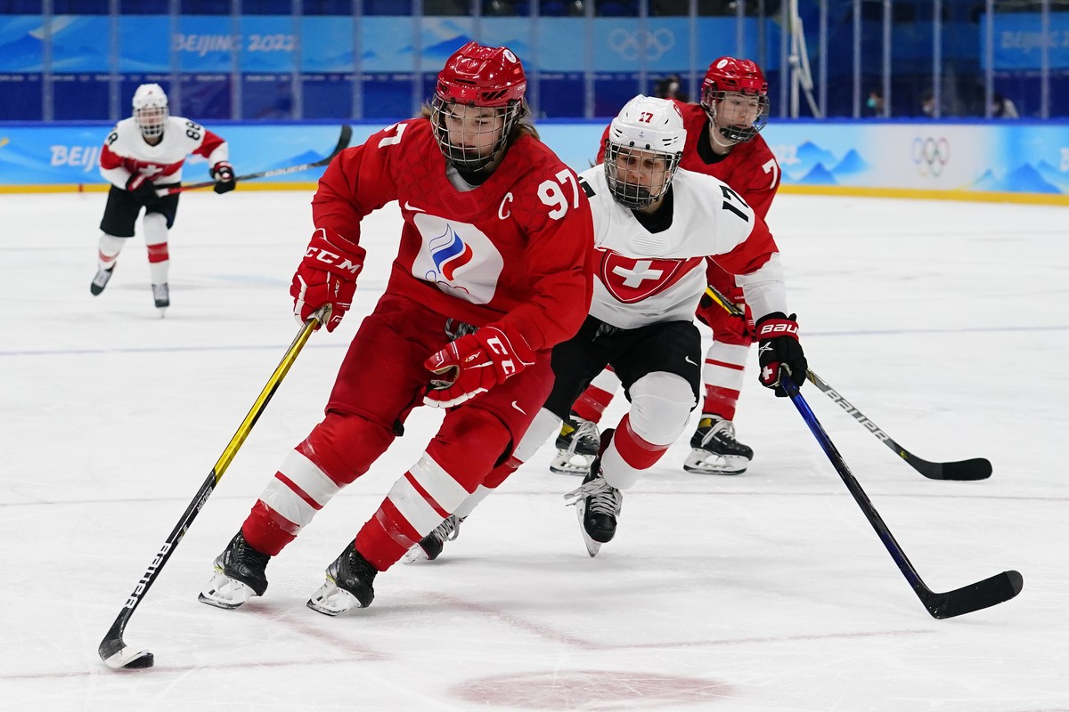 Russian Olympic Committee's Anna Shokhina (97) moves the puck ahead of Switzerland's Lara Christen (17) during a preliminary round women's hockey game at the 2022 Winter Olympics, Frida ...