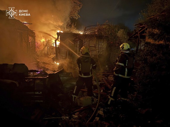 In this photo provided by the Ukrainian Emergency Service, emergency services personnel work to extinguish a fire following a Russian attack in Kyiv, Ukraine, Sunday, May 4, 2025. (Ukrainian Emergency ...