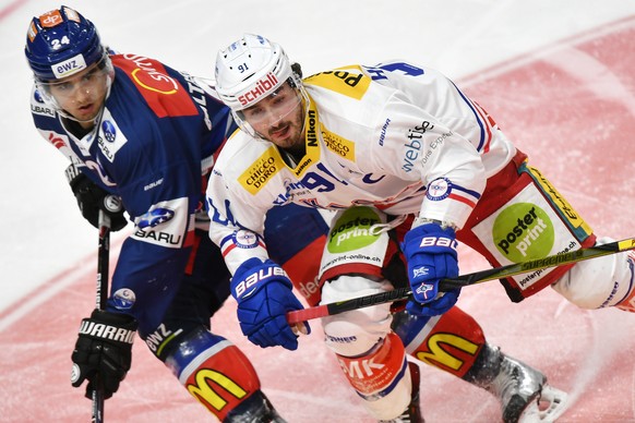 Der Zuercher Phil Baltisberger, links, gegen den Klotener Denis Hollenstein, rechts, beim Eishockeyspiel der National League ZSC Lions gegen den EHC Kloten im Hallenstadion in Zuerich am Samstag, 9. D ...