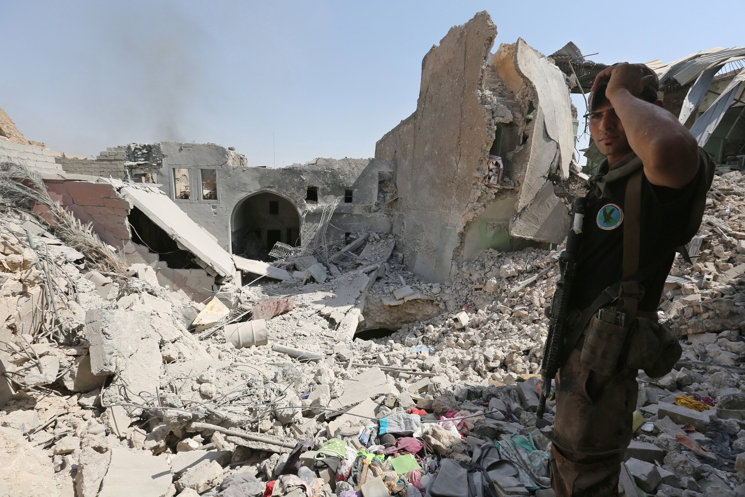 epa06068243 An Iraqi soldier stands next to destroyed houses in the old city area western Mosul, Iraq, 05 July 2017. Iraqi security forces are in the final stages of the gruelling battle to retake sec ...