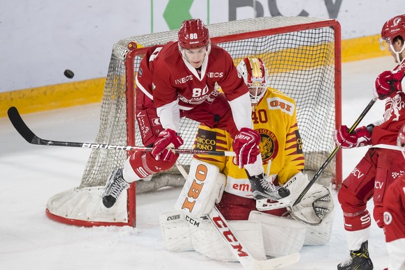 L&#039;attaquant lausannois Robin Leone, gauche, lutte pour le puck avec le gardien de Langnau Damiano Ciaccio, droite, lors de la rencontre du championnat suisse de hockey sur glace de National Leagu ...