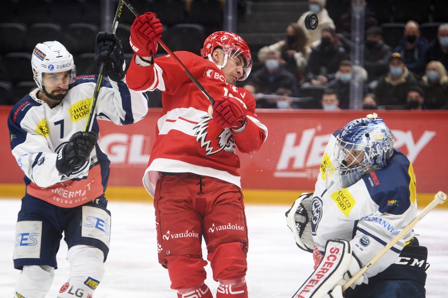 L&#039;attaquant lausannois Francis Pare, centre, lutte pour le puck avec le gardien tessinois Benjamin Conz, droite, et le defenseur tessinois Isacco Dotti, gauche, lors de la rencontre du championna ...