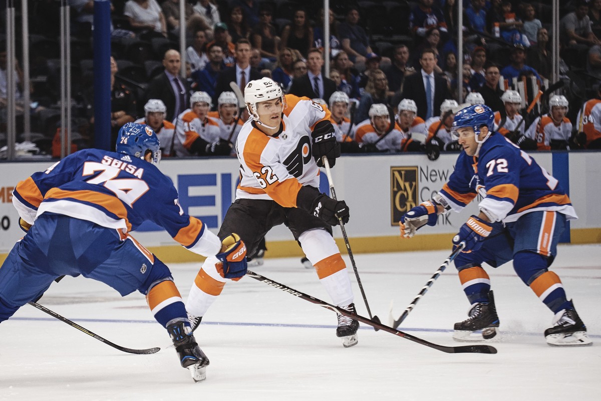 New York Islanders' Luca Sbisa, left, and Stephen Gionta, right, go for the puck against Philadelphia Flyers' Nicolas Aube-Kubel, during the first period of a preseason NHL hockey game in Ne ...