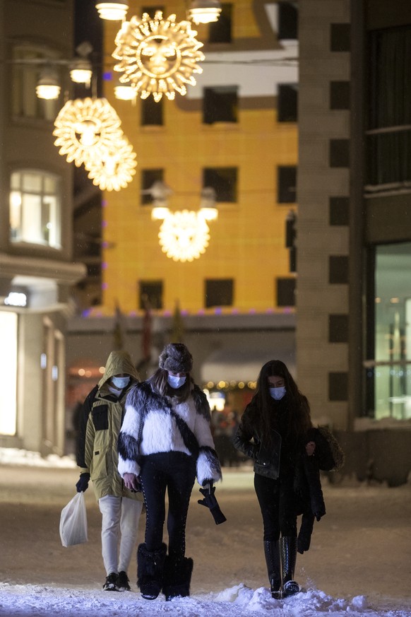 Passanten sind bei starkem Schneefall unterwegs in St. Moritz, am Samstag, 5. Dezember 2020. (KEYSTONE/Alexandra Wey)