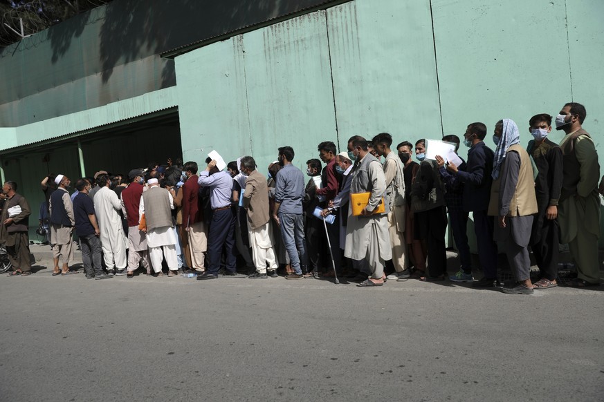 Afghans wait in long lines for hours to get visas in front of the Iranian embassy, in Kabul, Afghanistan, Sunday, Aug. 15, 2021. Officials say Taliban fighters have entered Kabul and are seeking the u ...