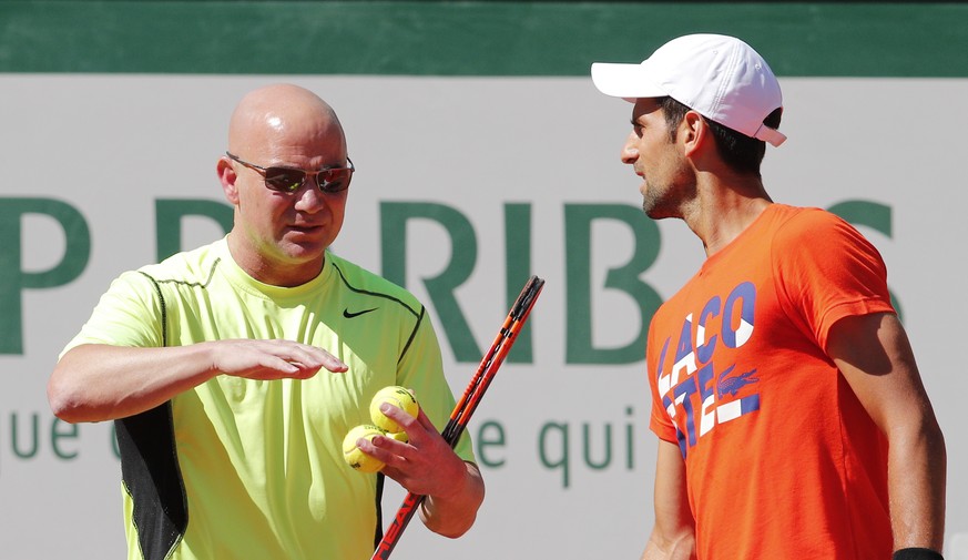 Defending champion Serbia&#039;s Novak Djokovic, right, listens to his new coach Andre Agassi, of the U.S, during a training session for the French Open tennis tournament at the Roland Garros stadium, ...