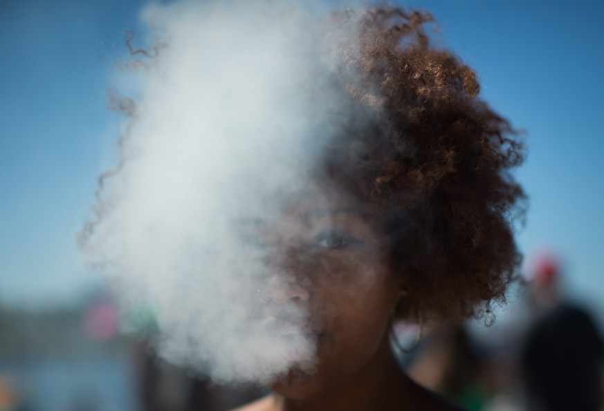 A woman exhales after taking a hit from a bong during 4/20, the annual day of celebration for cannabis culture lovers, at Sunset Beach in Vancouver, British Columbia, Wednesday April 20, 2016. Canada& ...