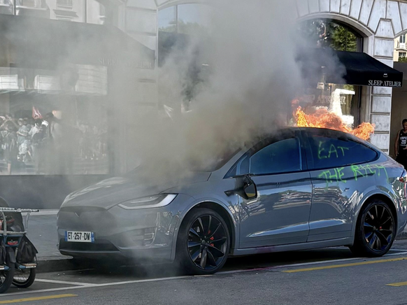 Un manifestant vient de bouter le feu à une voiture parquée à la rue Ami-Lévrier, face à la gare routière de Genève.