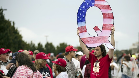 FILE - In this Aug. 2, 2018, file photo, a protester holds a Q sign as he waits in line with others to enter a campaign rally with President Donald Trump in Wilkes-Barre, Pa. Casino giant Caesars Ente ...