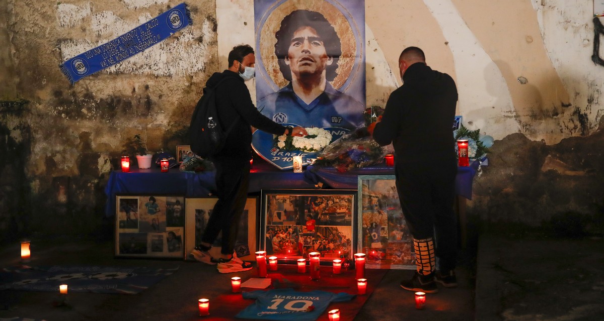 People gather and light candles to honor soccer legend Diego Maradona, at the popular "Quartieri Spagnoli" neighborhood, in Naples, Thursday, Nov. 26, 2020. Maradona died on Wednesday at the ...