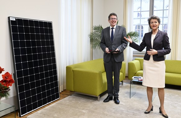 Die zurueckgetretene Bundesraetin Simonetta Sommaruga, rechts, schenkt ihrem Nachfolger im UVEK, Bundesrat Albert Roesti, ein Solarmodul, anlaesslich der Schluesseluebgabe im UVEK, am Freitag, 23. Dez ...