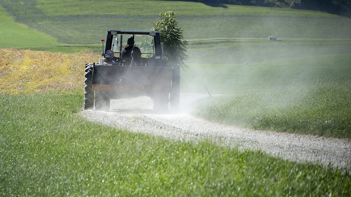 Ein Bauer mit dem Traktor unterwegs auf's Feld am Dienstag 3. September 2013 auf der Ahornalp. (KEYSTONE/Marcel Bieri)