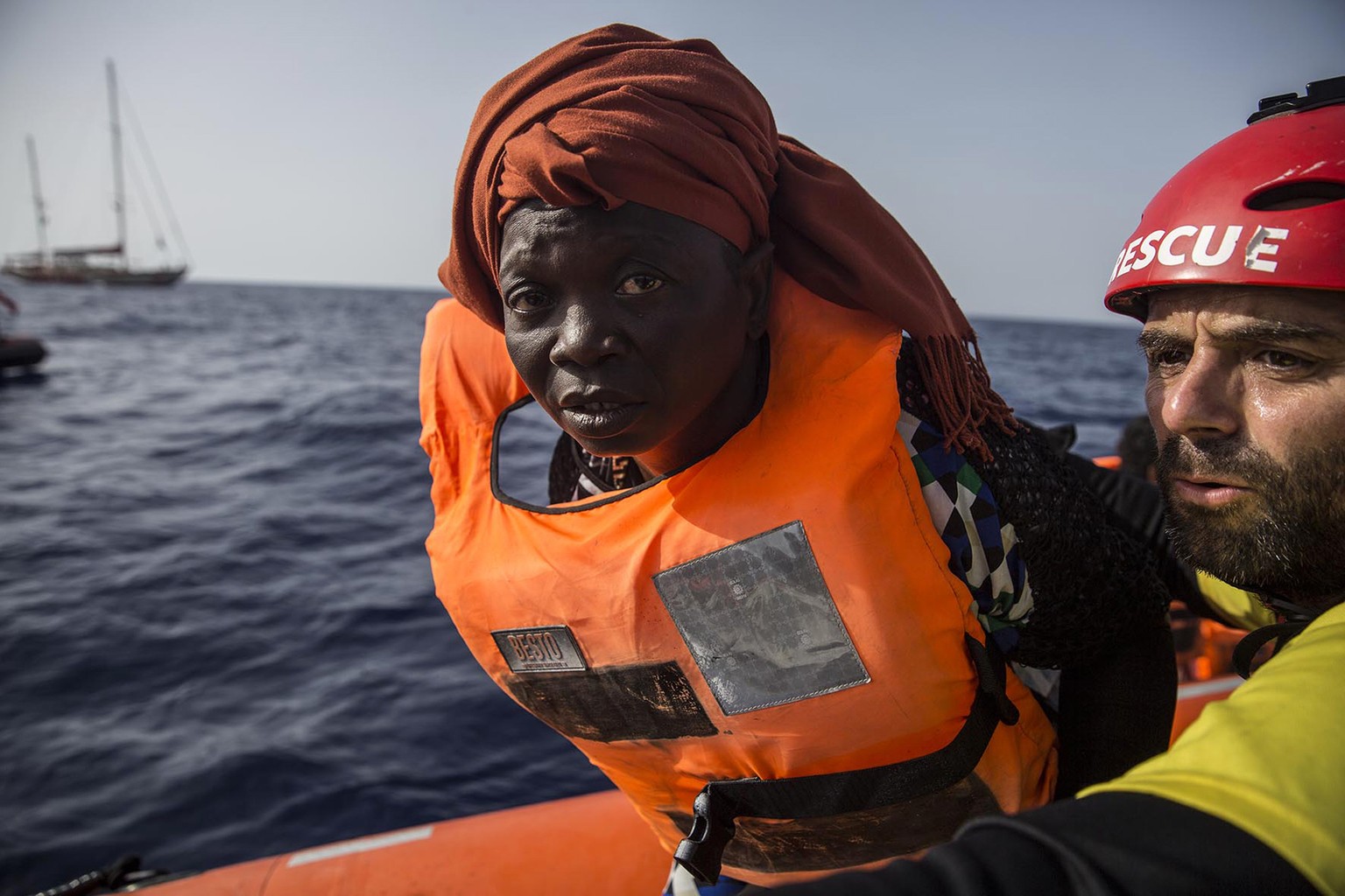 A migrant aboard a rubber dinghy off the Libyan coast is helped by rescuers aboard the Open Arms aid boat, of Proactiva Open Arms Spanish NGO, Saturday, June 30, 2018. 60 migrants were rescued as Ital ...