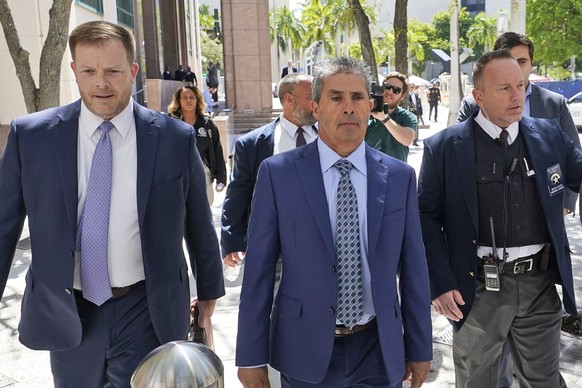 Carlos De Oliveira, center, an employee of Donald Trump&#039;s Mar-a-Lago estate, leaves a court appearance with attorney John Irving, left, at the James Lawrence King Federal Justice Building, Monday ...