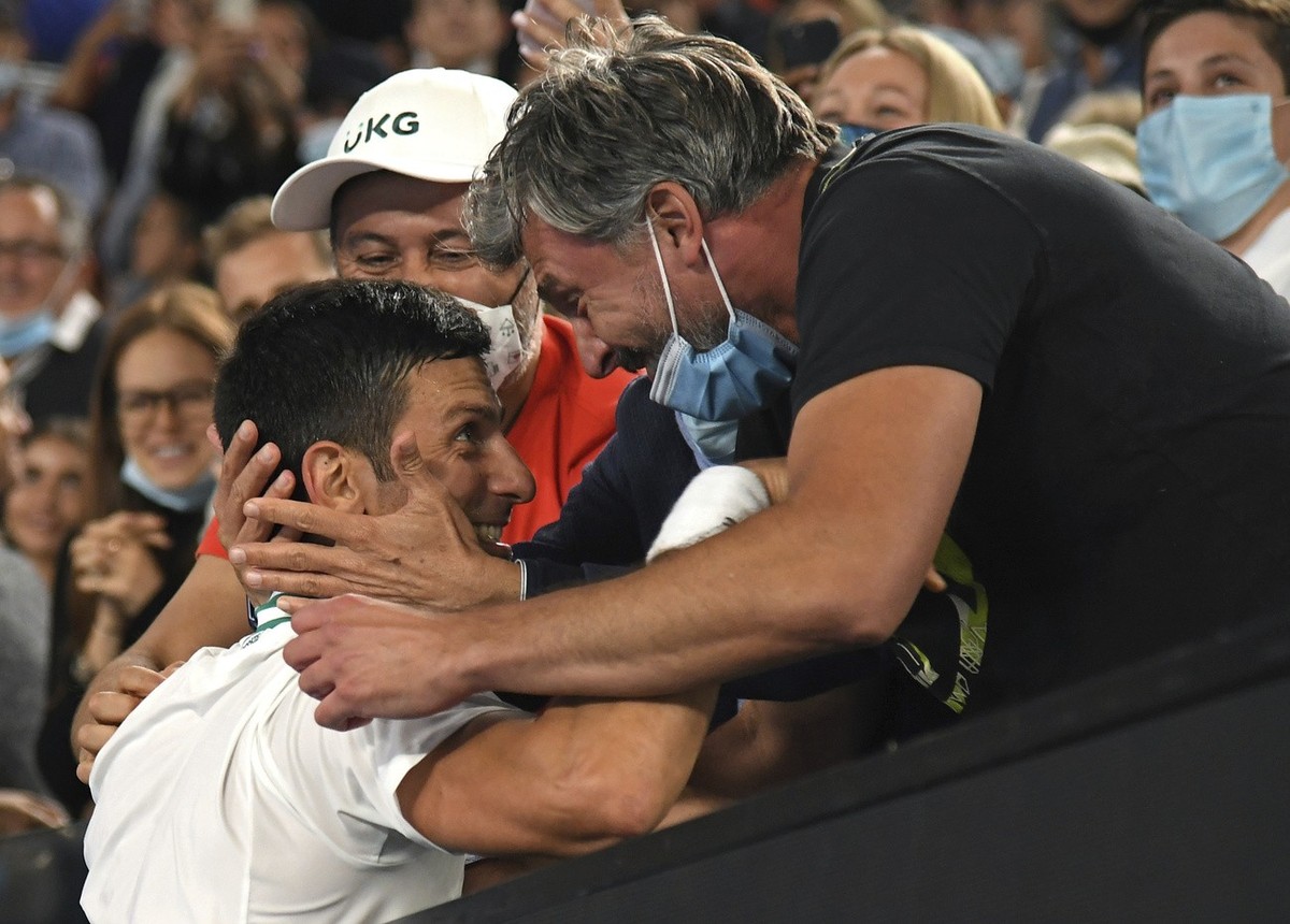Serbia's Novak Djokovic celebrates with Goran Ivanisevic, right, and his support team after defeating Russia's Daniil Medvedev in the men's singles final at the Australian Open tennis c ...