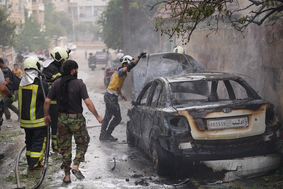 epa10907257 Members of the Syrian civil defense work at the site of an attack by Syrian forces against a neighborhood in Idlib, Syria, 08 October 2023. According to the UK-based Syrian Observatory for ...