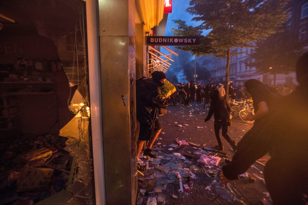 epa06074583 An alledged looter leaves a 'Budnikowski' shop in Schanzenviertel quarter during the G-20 summit in Hamburg, Germany, 07 July 2017. The G20 Summit (or G-20 or Group of Twenty) is ...