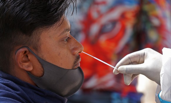 epa09699913 A man undergoes a Covid/19 swab test at the railway station in Bangalore, India 21 January 2022. The Karnataka State Government on 21 January lifted the weekend curfew with immediate effec ...