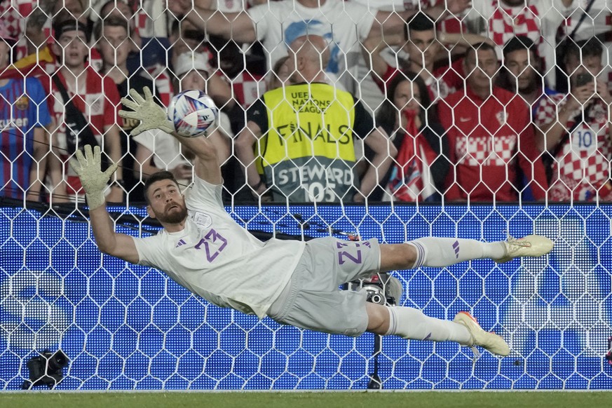 Spain goalkeeper Unai Simon stops a penalty shot from Croatia&#039;s Bruno Petkovic during a penalty shootout at the end of the Nations League final soccer match between Croatia and Spain at De Kuip s ...