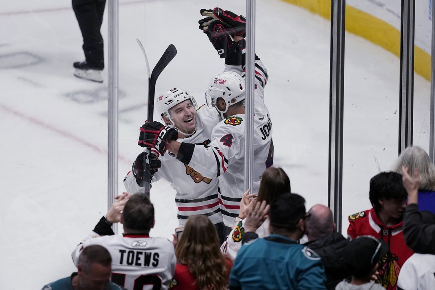 Chicago Blackhawks defenseman Seth Jones, right, is congratulated by center Philipp Kurashev after scoring against the San Jose Sharks in overtime of an NHL hockey game in San Jose, Calif., Saturday,  ...