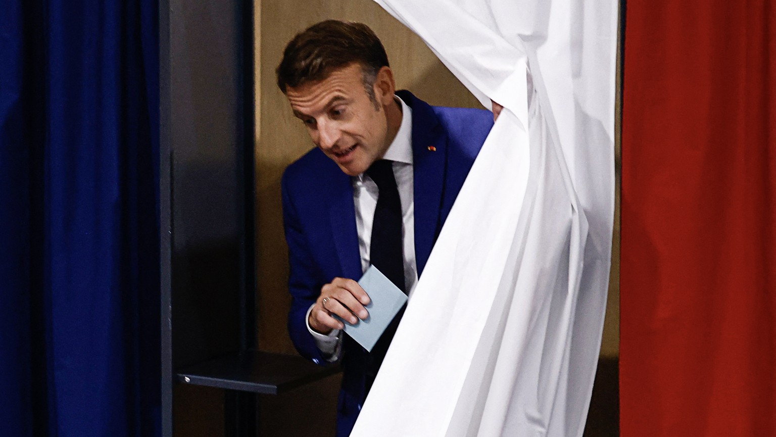 epa11447115 French President Emmanuel Macron leaves a voting booth at a polling station during the first round of the early French parliamentary elections, in Le Touquet-Paris-Plage, northern France,  ...