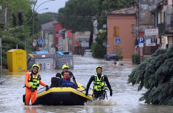 epa10633968 A family is rescued by the firefighters in Coccolia, near Ravenna, Central Italy, 17 May 2023. A fresh wave of torrential rain is battering Italy, especially the northeastern region of Emi ...