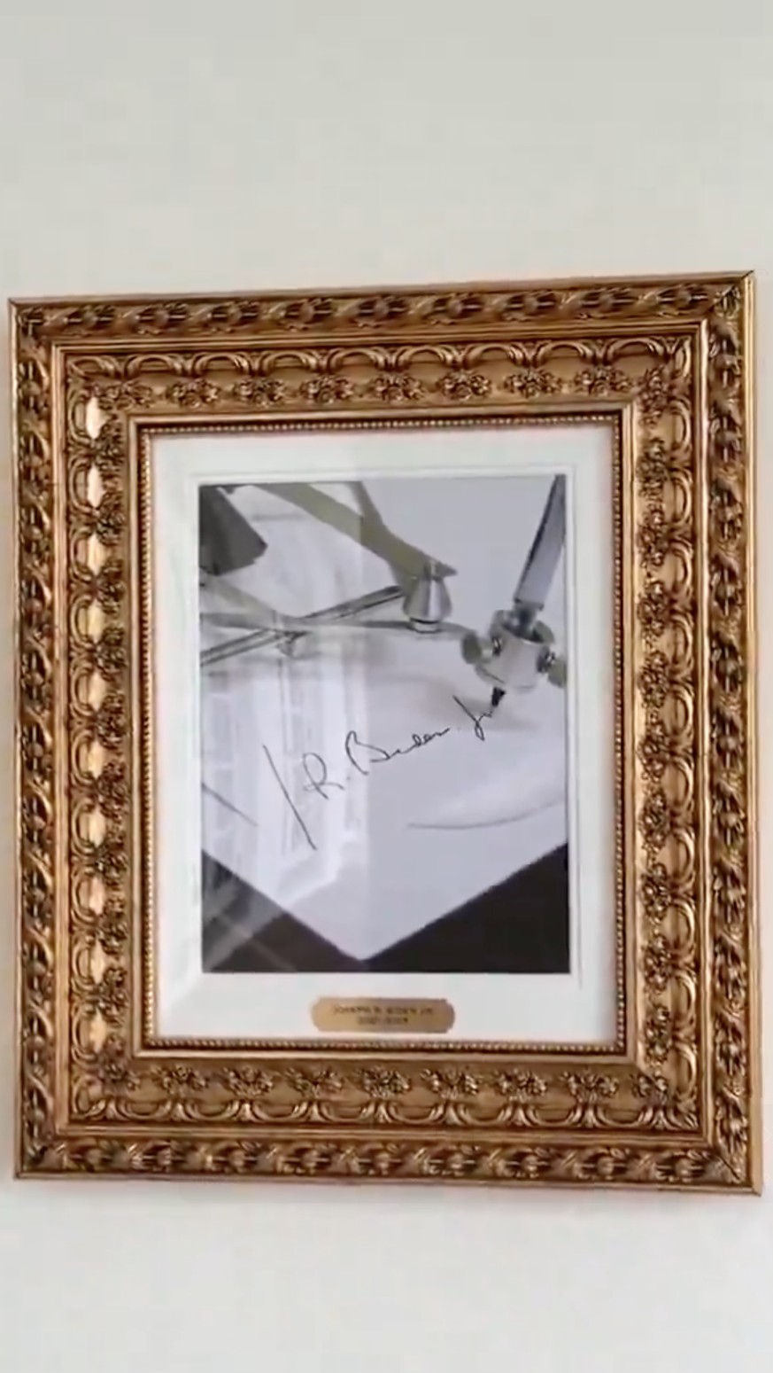 Trump hängt statt Portrait von Biden ein Foto einer Unterschriftenmaschine in die Galeri
